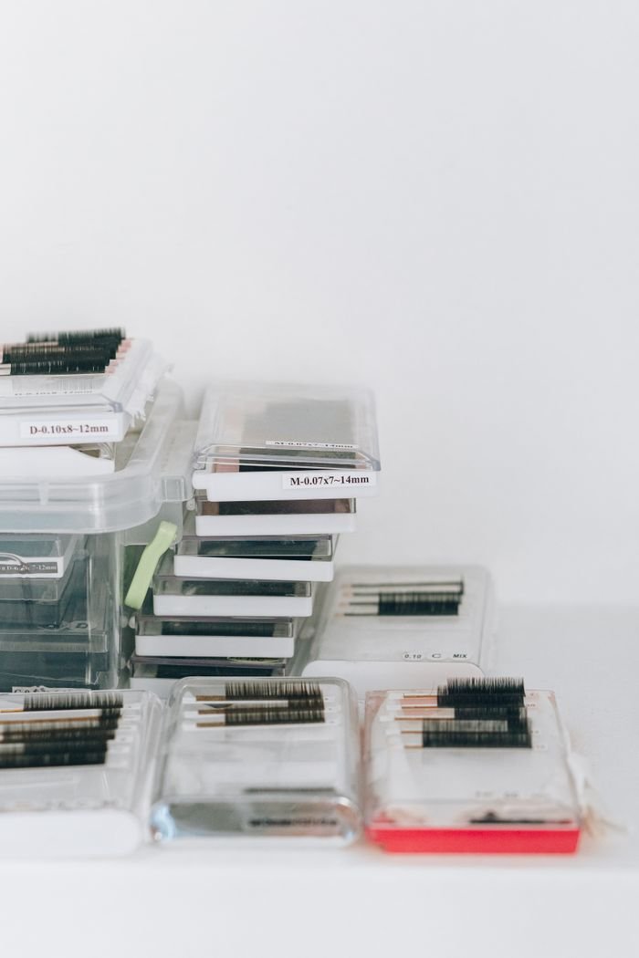Clear plastic containers holding various eyelashes and extensions for beauty use.